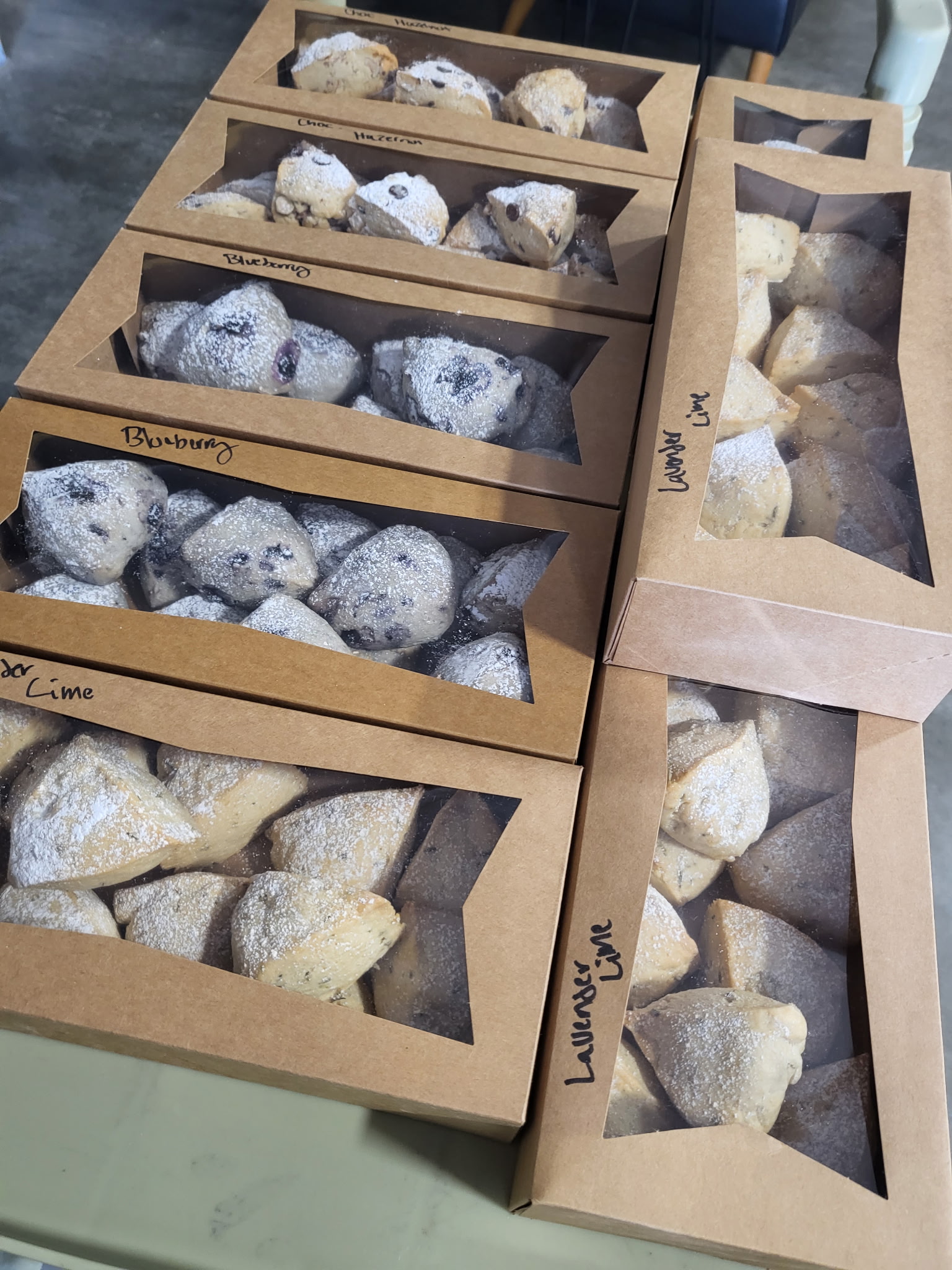 Multiple SconeGrown bakery boxes labeled by flavor